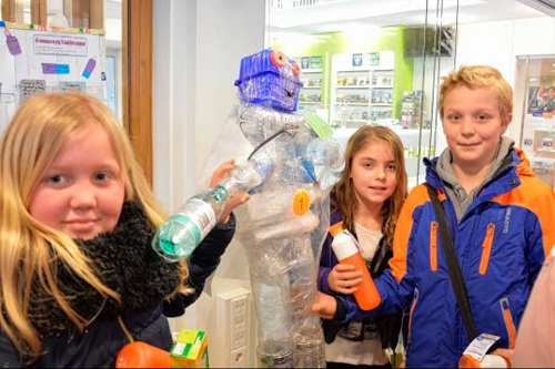 kinderen werken met plastic flessen