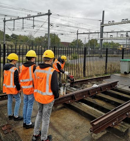 leerlingen krijgen uitleg bij spoorrails